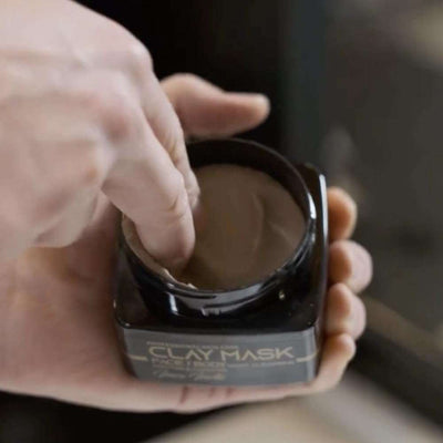 Black Edition Clay Mask – 240 ml being applied, featuring deep-cleansing formula with Inca Inchi oil.